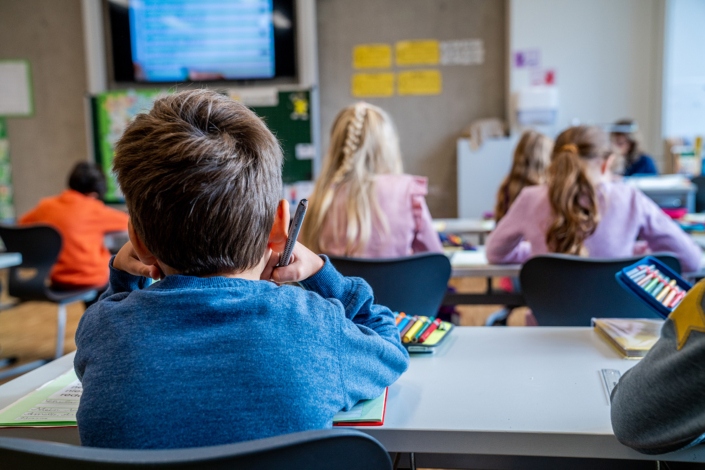 Schüler sitzen in der Klasse mit Videotafel